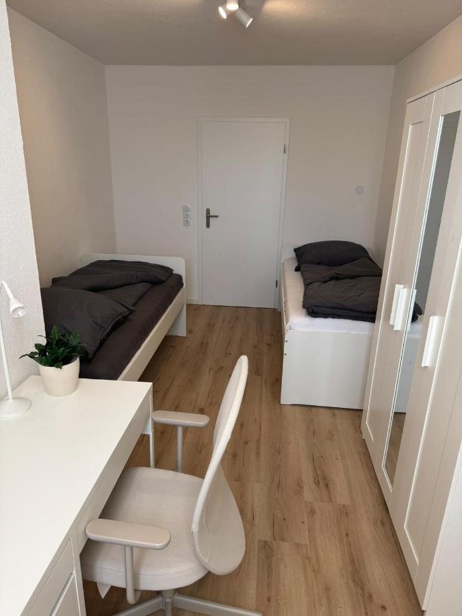 Room with two single beds and a desk
